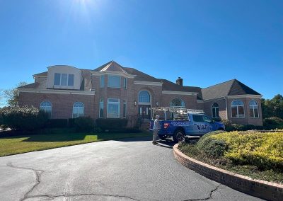 roundabout driveway with van's rain gutters employee and truck with house with seamless white gutters behind them shamong nj van's rain gutters south jersey